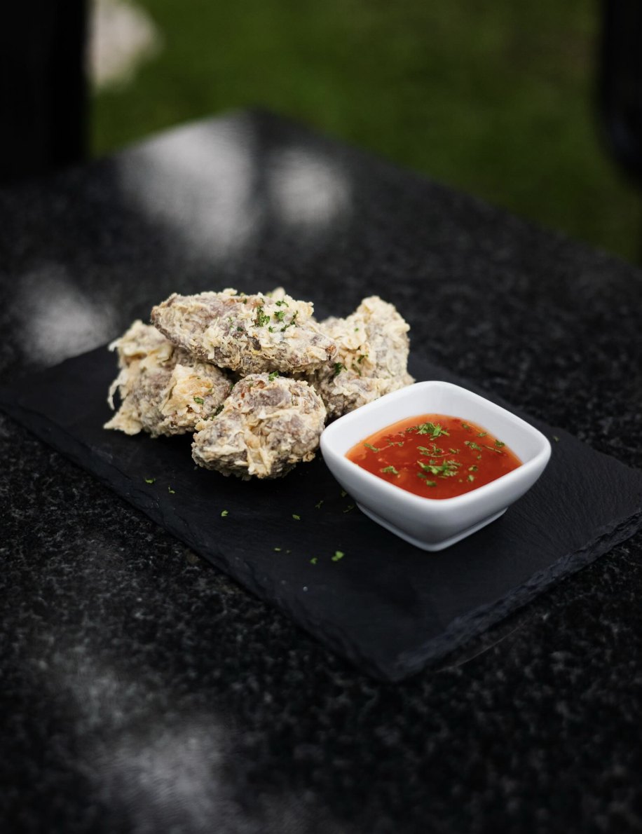 Crispy bites with sweet chilli dip on slate