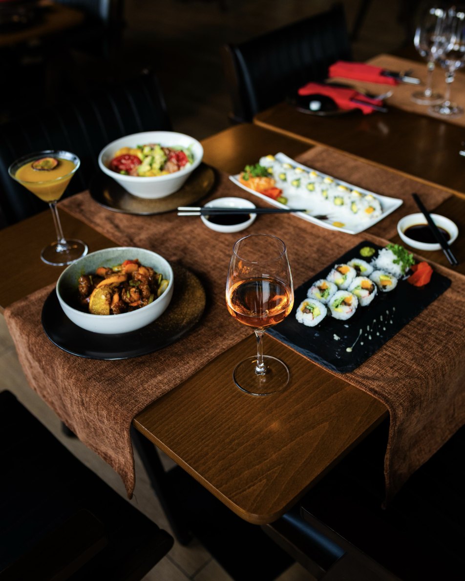 Sushi rolls, a curry bowl and a rosé glass on the Kultura table