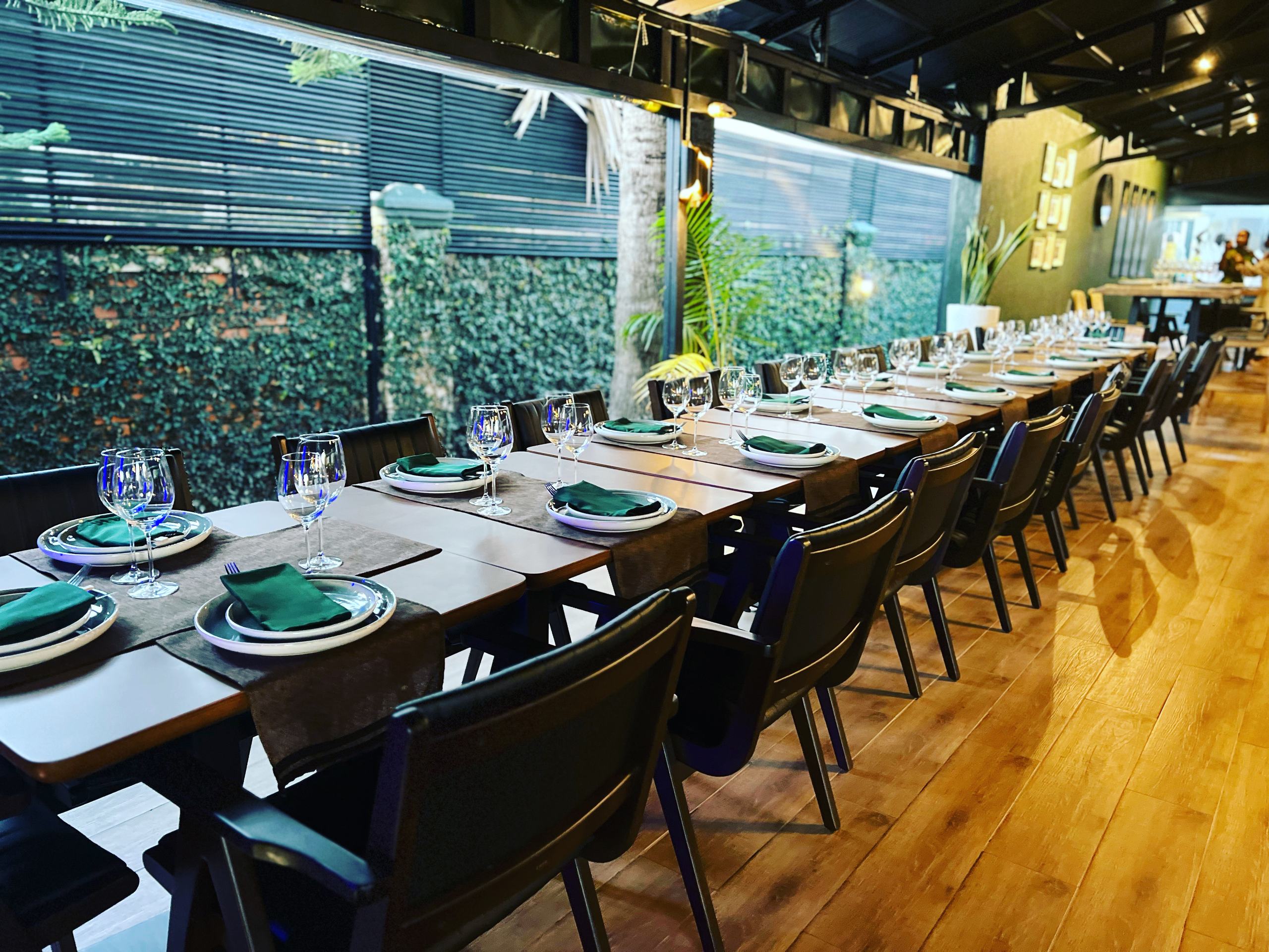 The long communal table beside the green wall at Kultura